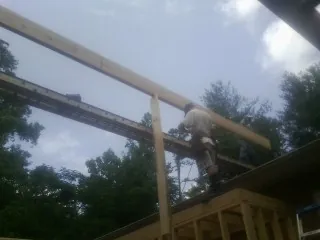 Carpenter setting a ridge beam over a new addition frame — Ice Dam Removal by Roofing Brothers in Woodberry Forest