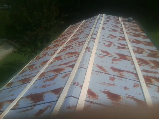 Rusted metal roof panels with new wood purlins before replacement — Storm Damage Roof Repair in Woodberry Forest by Roofing Brothers