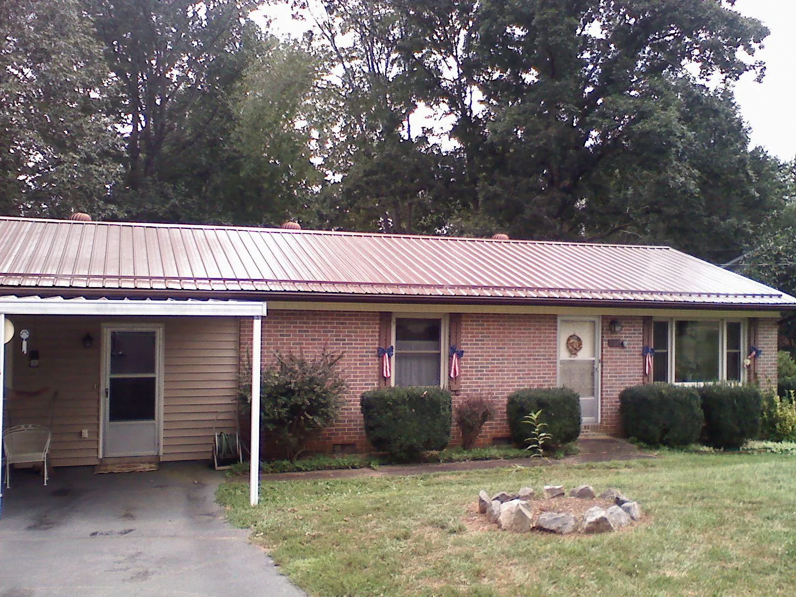Bronze metal roof and carport on a brick ranch home — Roof Repair work by our crew in Woodberry Forest